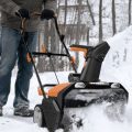 person using Worx cordless snow blower to remove snow