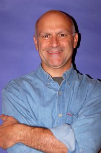 Joe Truini in front of purple background