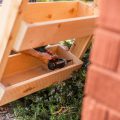 drilling in wooden plant holder into legs next to brick
