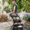 man pulling away worx pressure washer on sidewalk