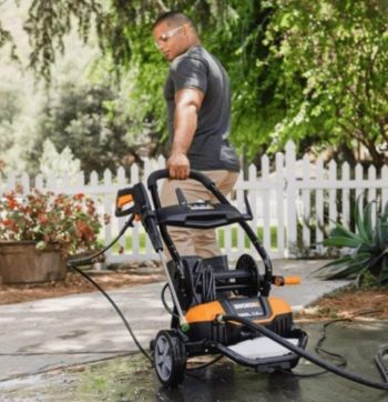 man pulling away worx pressure washer on sidewalk