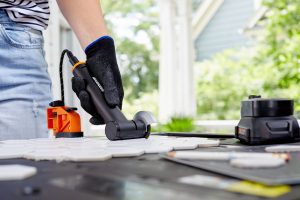 person using angle grinder to cut tiles