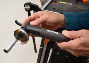 close up of hands holding black makerx angle grinder