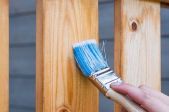 paint brush staining wood deck railing