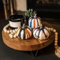 colored pumpkins on wooden stand next to candle