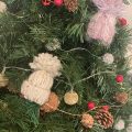 yarn weaved holiday hats on fake christmas tree