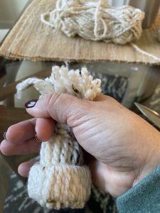 holding top of yarn weaved hat