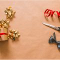 brown paper wrapper present next to red ribbon and scissors