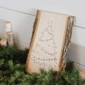 christmas tree on wooden block leaning on wall