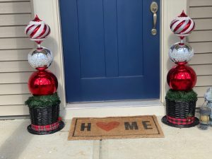 red white ornaments in hat plant pot in front of blue door