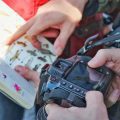close up of person holding camera looking at photos of birds