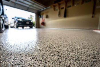 clean garage floor with garage door open and car entering