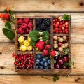 square box with nine 3x3 compartments filled with berries and fruits