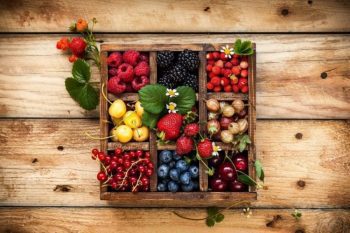 square box with nine 3x3 compartments filled with berries and fruits