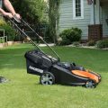 person pushing Worx battery powered lawn mower on grass