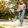 woman using worx hydroshot power cleaner to clean pool deck