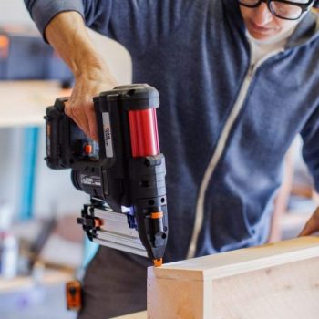 man using worx nitro cordless nail gun to drive nail into wood