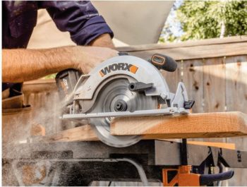 person using Worx circular saw to cut board