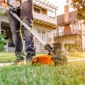 close up of person using worx battery powered weed eater to trim grass