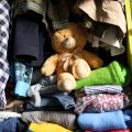 clothes and teddy bear stored inside closet cubby