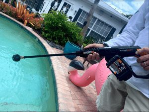 man holding holding worx pressure washer above pool