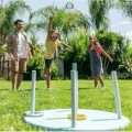 father and two daughters playing ring toss game with homemade game set
