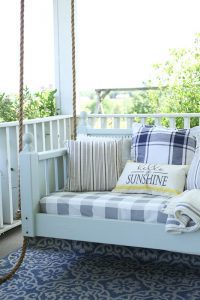 white porch swing with sunshine pillow