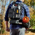 Showing the back of man carrying a battery back for 80v batteries and blower