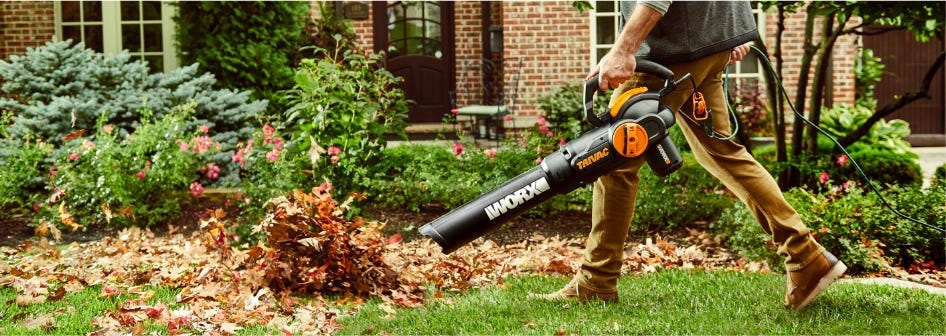 WORX TRIVAC 12-Amp Electric 3-IN-1 Blower / Mulcher / Yard Vacuum blowing leaves in green yard