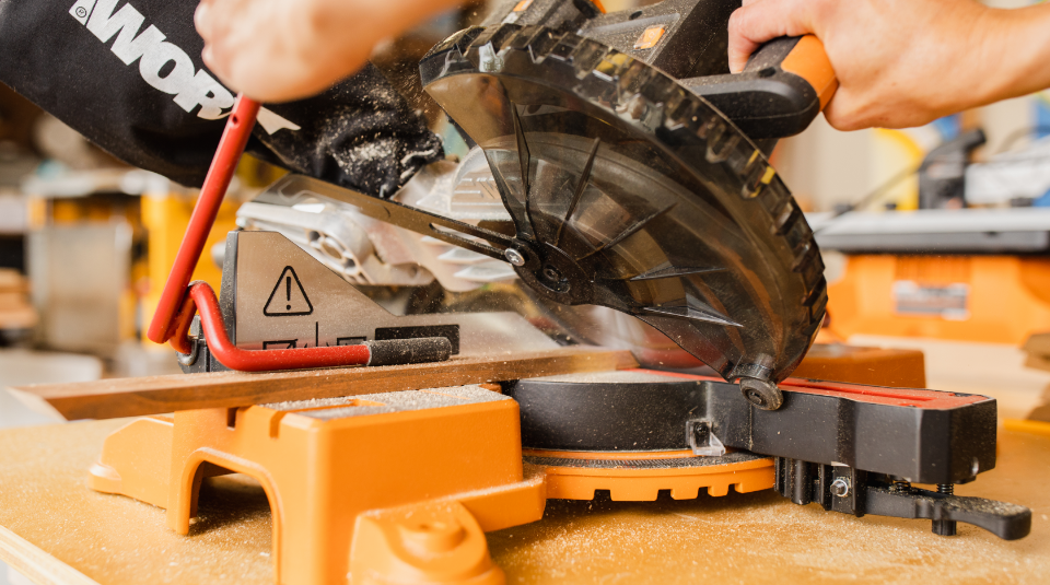 Miter Saw Power Tool close up of person using a Worx miter saw on top of a wooden table