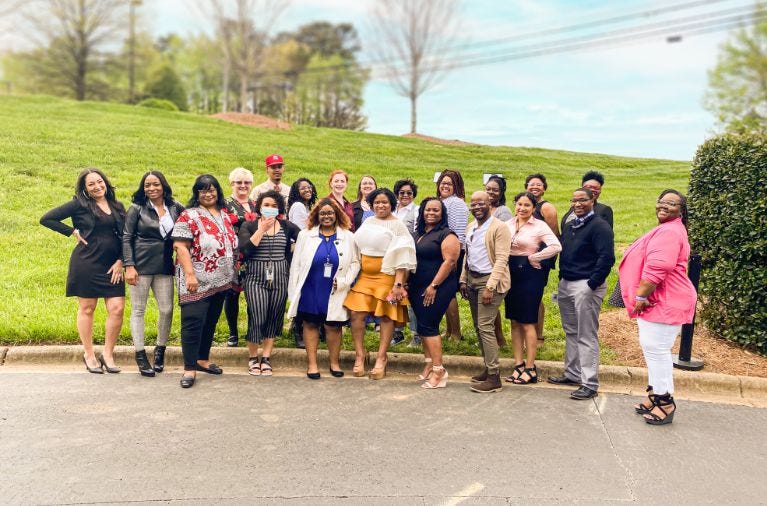 Worx customer service team standing in front of open grass field smiling