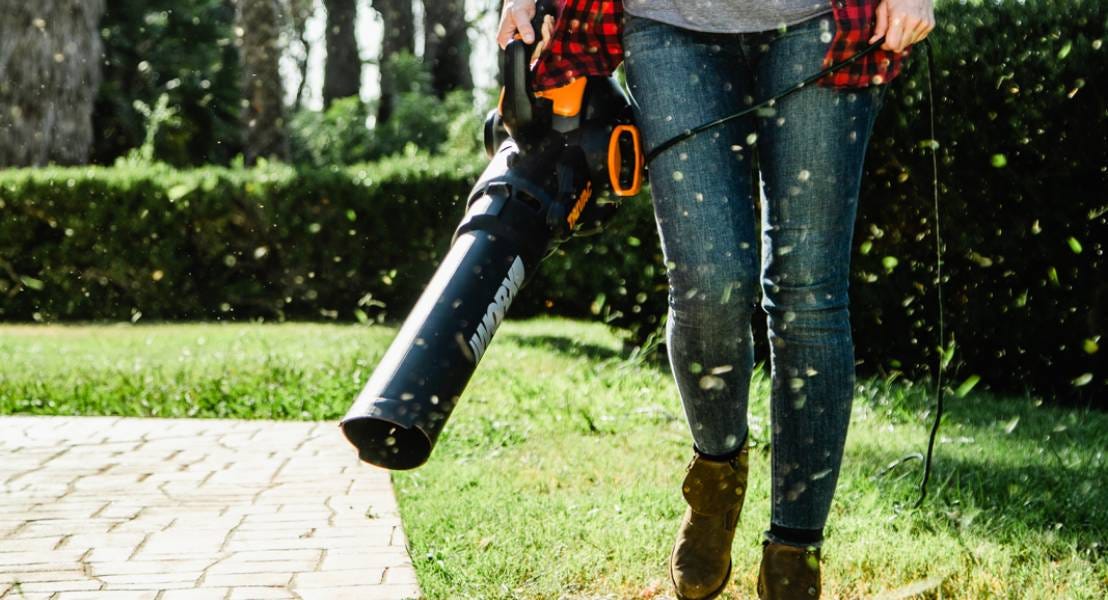 Worx Trivac blower being used to blow grass off of stone patio