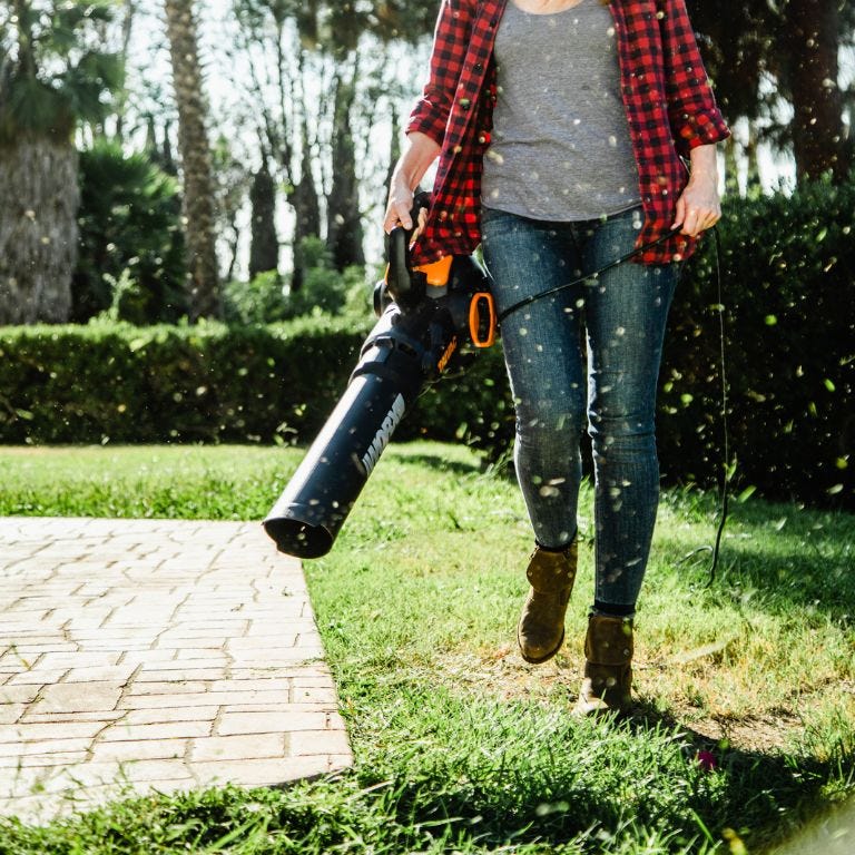 Worx Trivac blower being used to blow grass off of stone patio