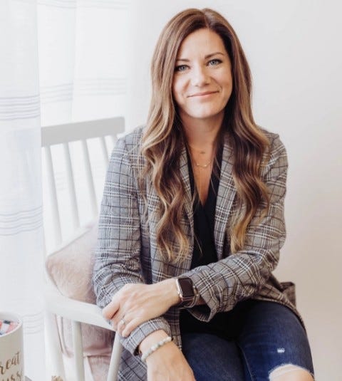 Portrait shot of lady sitting in chair with jacket and blue jeans