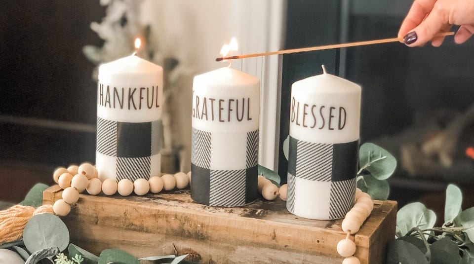 Three candles sitting on one wood piece of decoration while being lit by flame