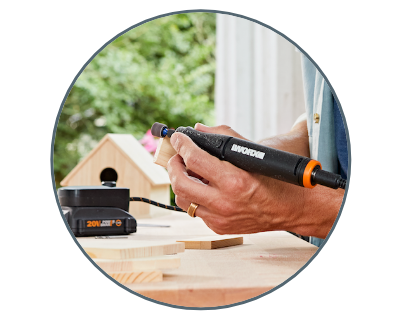 Man holding rotary tool sanding down a piece of wood