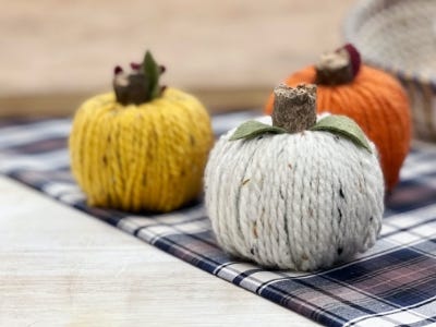 white, orange, yellow yarn ball on plaid cloth