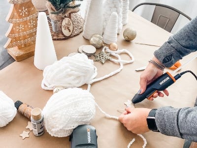 using mini glue gun to glue yarn string to back star