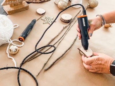 holding hot glue gun and adding hot glue into whole 