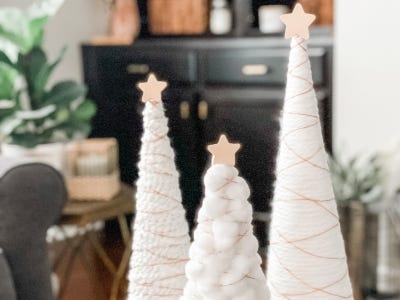 three yarn trees with lights off sitting next to each other