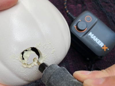 Rotary tool cutting circle into white pumpkin