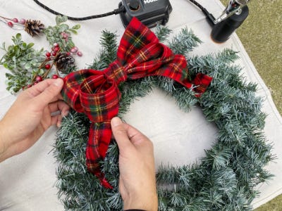 assembling wreath with red/green plaid bow