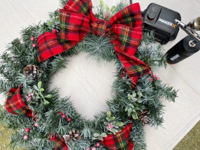 Airbrushed forsted wreath with plaid bow on tarp