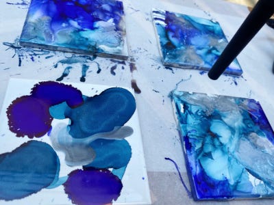 3 coasters with different designs from mini blower and one still splattered 