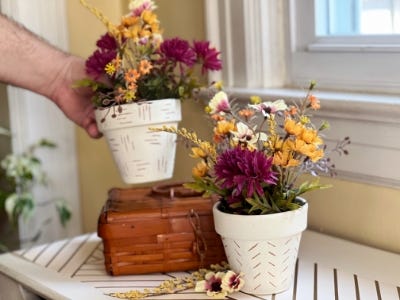 hand picking up one hand etched pots and one is on book on wooden table