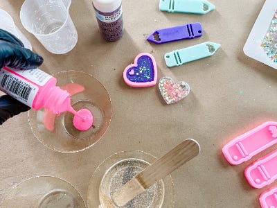 pouring pink paint into clear cup