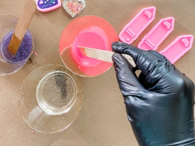 mixing pink paint into clear cup