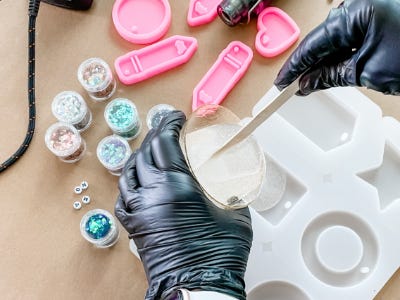 pouring a thin amount of resin into plastic mold