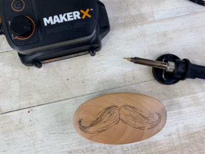 wood and metal laying next to a man drawn mustache on wood brush