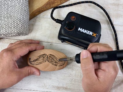 wood and metal engraving mustache onto brush